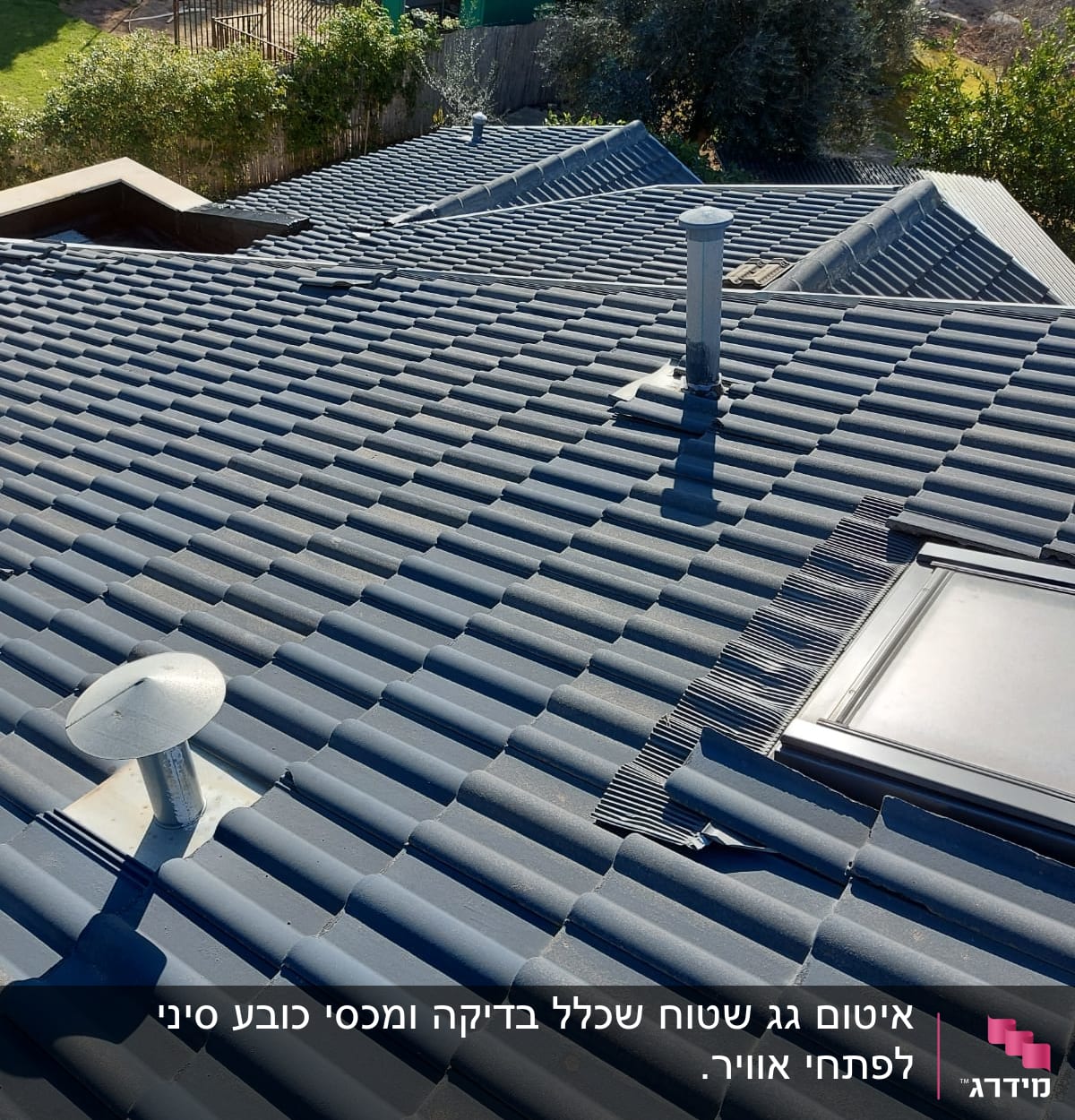 רעפים אפורים עם ארובה וחלון גג על גג בית